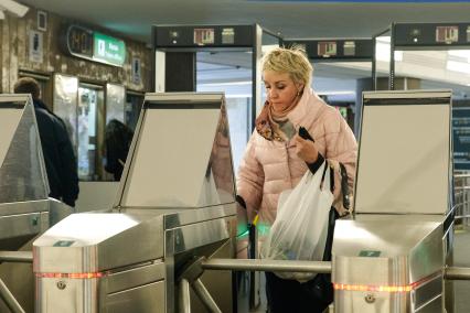 Санкт-Петербург. Женщина без медицинской маски проходит через турникет.