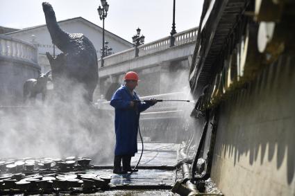 Москва. Сотрудники коммунальных служб моют фонтаны на Манежной площади.