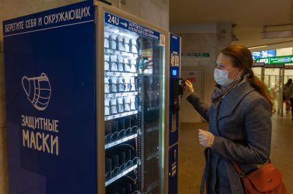 Санкт-Петербург.  Девушка  покупает маску в автомате в метро.