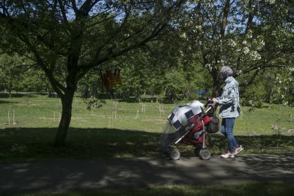 Екатеринбург. Женщина гуляет с реенком в детской коляске, в парке во время режима самоизоляции введеного для нераспространения новой коронавирусной инфекции COVID-19