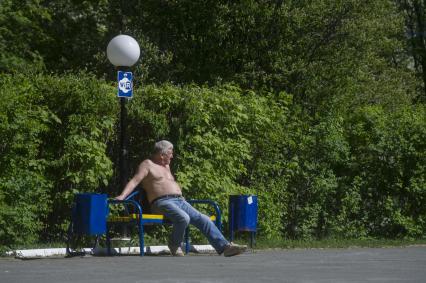 Екатеринбург. Мужчина загорает на скамейке в парке во время режима самоизоляции введеного для нераспространения новой коронавирусной инфекции COVID-19