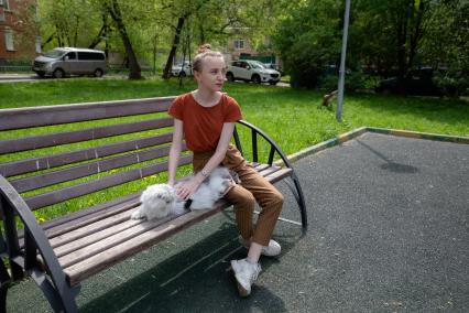 Москва. Девушка гуляет с кошкой во дворе.