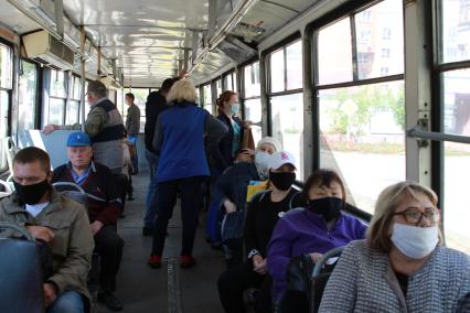 Иркутск.   Пассажиры в медицинских масках в трамвае.
