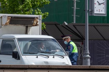 Москва. Сотрудник ДПС проверяет документы у водителя.