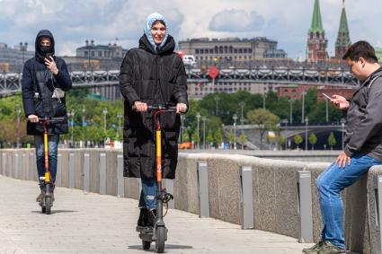 Москва. Девушки на самокатах на Берсеневской набережной.