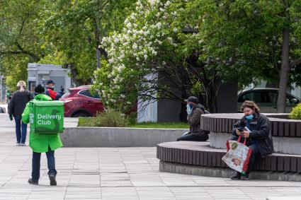 Москва. Сотрудник сервиса доставки еды в одном из парков города.