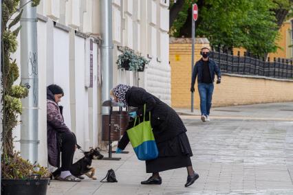 Москва. Пожилая женщина подает милостыню.