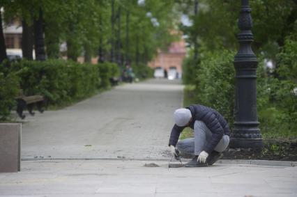 Екатеринбург. Рабочий укладывает гранитную плитку в парке