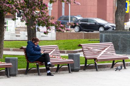 Москва. Женщина  на скамейке в сквере.