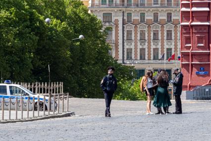 Москва. Сотрудники полиции проверяют документы у девушек на Красной площади.