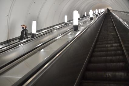 Москва. Пассажиры в медицинских масках на эскалаторе метро.