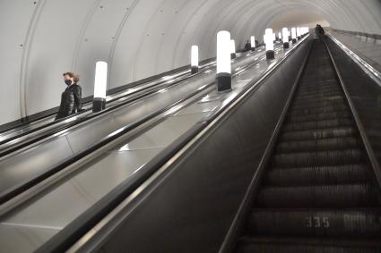 Москва.  Пассажиры в медицинских масках на эскалаторе метро.