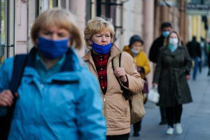 Санкт-Петербург. Прохожие в медицинских масах на улице города.медицинской маске на самокате.