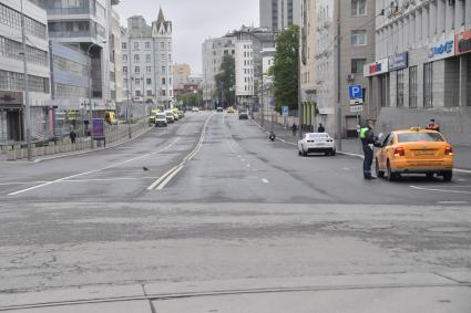 Москва.  Инспектор ДПС во время проверки электронного пропуска у водителя такси.