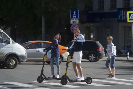 Екатеринбург. Парень с девушкой едут на арендованых самокатах