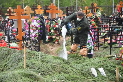 Москва. Работник Бутовского кладбища во время похорон умерших после заражения коронавирусом.