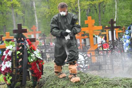 Москва. Работник Бутовского кладбища во время похорон умерших после заражения коронавирусом.