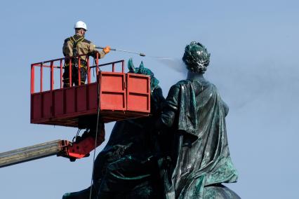 Санкт-Петербург. Сотрудник коммунальной службы моет памятник Петру I на Сенатской площади.