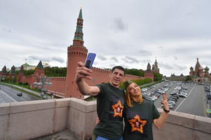 Москва. Молодые люди фотографируются на  Большом Москворецком мосту во время  воздушного парада Победы в Москве.