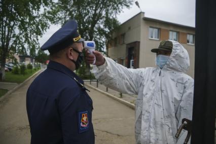 Свердловская область. Окружной сборный пункт (ОСП). Военнослужащий измеряет температуру тела офицеру при входе на территорию. Во время призывной кампании, для нераспространения новой коронавирусной инфекции COVID-19 на территории ОСП введен особый противоэпидемический режим