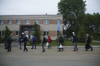 Свердловская область. Окружной сборный пункт (ОСП).  Во время призывной кампании, для нераспространения новой коронавирусной инфекции COVID-19 на территории ОСП введен особый противоэпидемический режим. На фото: группа призывников с личными вещами и в защитных масках на входе в ОСП