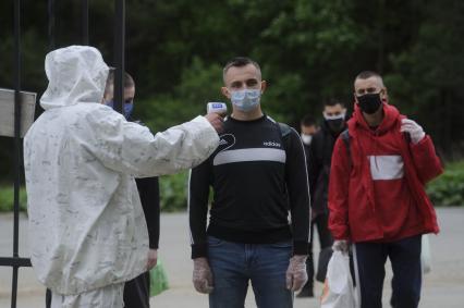 Свердловская область. Окружной сборный пункт (ОСП). Военнослужащий измеряет температуру тела призывнику при входе на территорию. Во время призывной кампании, для нераспространения новой коронавирусной инфекции COVID-19 на территории ОСП введен особый противоэпидемический режим