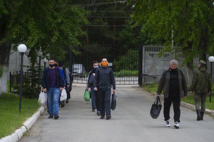 Свердловская область. Окружной сборный пункт (ОСП).  Во время призывной кампании, для нераспространения новой коронавирусной инфекции COVID-19 на территории ОСП введен особый противоэпидемический режим. На фото: группа призывников с личными вещами и в защитных масках на входе в ОСП