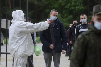 Свердловская область. Окружной сборный пункт (ОСП). Военнослужащий измеряет температуру тела призывнику при входе на территорию. Во время призывной кампании, для нераспространения новой коронавирусной инфекции COVID-19 на территории ОСП введен особый противоэпидемический режим