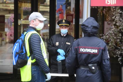 Москва. Охранник в медицинской маске у дверей магазина  ГУМ , где возобновлена торговля  в рамках очередного этапа отмены ограничений, введенных из-за коронавируса.