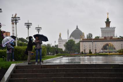 Москва. Прохожие гуляют на территории  ВДНХ , открывшегося  для посещений в рамках второго этапа снятия ограничений в Москве, введенных для предотвращения распространения коронавируса.