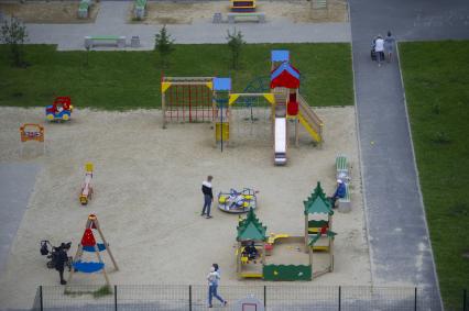 Екатеринбург. Люди гуляют на детской площадке во дворе