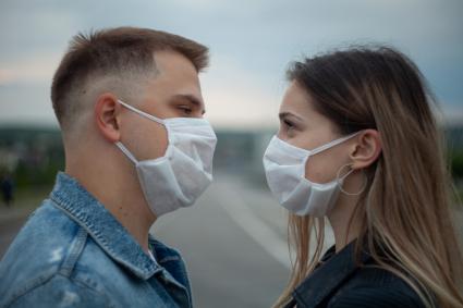 Пермь. Молодой человек с девушкой в медицинских масках во время прогулки.