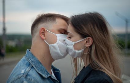 Пермь.  Молодой человек с девушкой в медицинских масках во время прогулки.