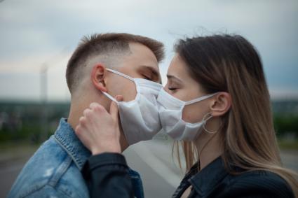 Пермь. Молодой человек с девушкой в медицинских масках во время прогулки.