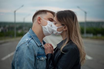 Пермь. Молодой человек с девушкой в медицинских масках во время прогулки.