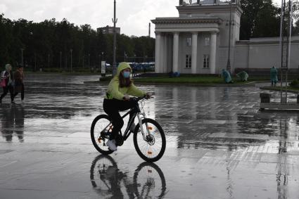 Москва.  Юноша на велосипеде у главного входа  ВДНХ.