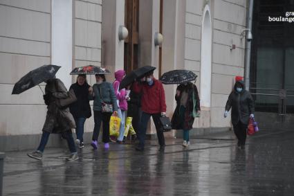 Москва.  Прохожие под дождем у метро Парк Культуры.