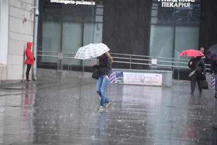 Москва.  Прохожие под дождем у метро Парк Культуры.