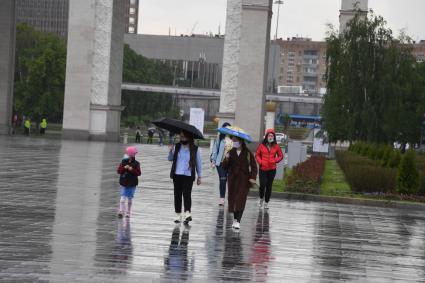 Москва.  Прохожие у центрального входа на ВДНХ.