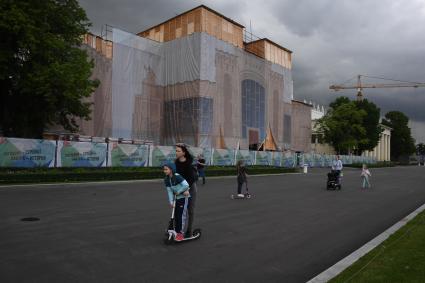 Москва.  Посетители катаются на самокатах по аллеям ВДНХ.