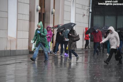 Москва.  Прохожие под дождем у метро Парк Культуры.