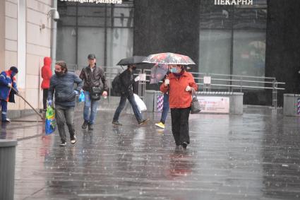 Москва.  Прохожие под дождем у метро Парк Культуры.