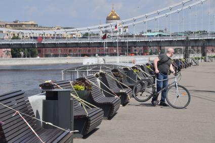 Москва.  Мужчина с велосипедом на Пушкинской набережной Парка Горького.