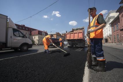 Екатеринбург. Дорожные рабочие укладывают асфальт на ремонтируемой дороге