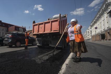 Екатеринбург. Дорожная рабочая-женщина укладывает асфальт на ремонтируемой дороге