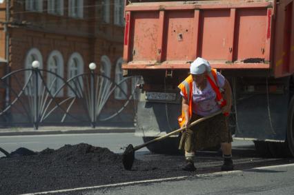 Екатеринбург. Дорожная рабочая-женщина укладывает асфальт на ремонтируемой дороге