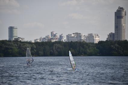 Москва. Молодые люди занимаются виндсерфингом на пляже в Строгинской пойме.