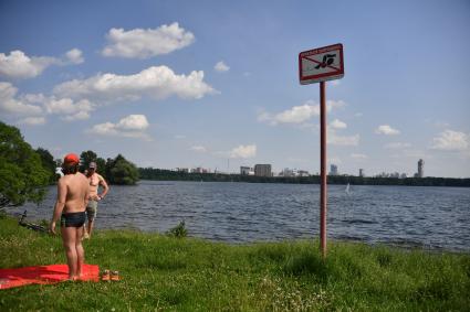 Москва.  Мужчины отдыхают на пляже Строгинской поймы.