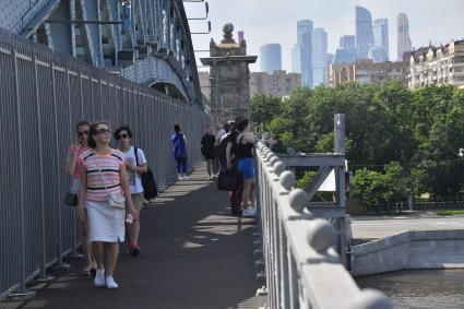 Москва.  Отдыхающие гуляют на Андреевском мосту.