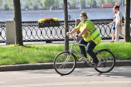 Москва.  Женщина в медицинской маске на велосипеде в парке Горького после отмены режима самоизоляции, введенного  из-за пандемии коронавируса.